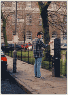 Someone paying at pay and display meter